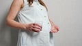 Unrecognizable pregnant woman holding medicine in one hand and in another glass of water