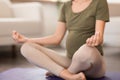 Unrecognizable pregnant woman meditating in lotus position practicing yoga indoor Royalty Free Stock Photo