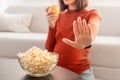 Unrecognizable Pregnant Woman Refusing Unhealthy Popcorn Choosing Apple Indoor, Cropped Royalty Free Stock Photo