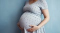 Unrecognizable pregnant woman smiling and holding her big belly. Generative AI Royalty Free Stock Photo