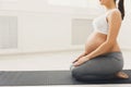 Unrecognizable pregnant woman training yoga in lotus pose Royalty Free Stock Photo