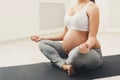 Unrecognizable pregnant woman training yoga in lotus pose Royalty Free Stock Photo