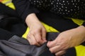 unrecognizable professional seamstress, hand tailoring, sews fabric by hand.