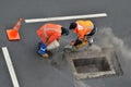 Unrecognizable road workers cutting asphal