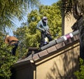 Unrecognizable Roofers working on a residential roof wearing hats