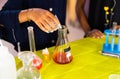 Unrecognizable school kid adding chemical solution drops in to filtering flask at chemistry laboratory - concpet o f science