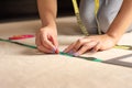 Unrecognizable woman is measuring fabric using rules and measuring tape Royalty Free Stock Photo