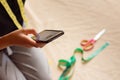 Unrecognizable seamstress is using her smartphone at her workshop