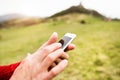 Unrecognizable senior sportsman in nature with smart phone.