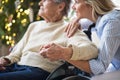 A senior woman in wheelchair with a health visitor at home at Christmas time. Royalty Free Stock Photo