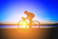 Unrecognizable silhouette man riding bicycle against sunset sky Royalty Free Stock Photo