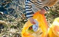 Unrecognizable small child collecting rubbish outdoors in nature, plogging concept.