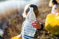 Unrecognizable small child collecting rubbish outdoors in nature, plogging concept.