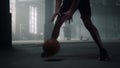 Sportsman legs playing basketball. Afro man hands bouncing basketball ball