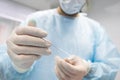 Unrecognizable surgeon holding medical needles for facelift operation