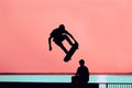Unrecognizable teenage boy silhouette showing high jump tricks on scooter against Royalty Free Stock Photo