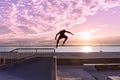 Unrecognizable teenage boy silhouette showing high jump tricks on scooter against Royalty Free Stock Photo