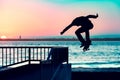 Unrecognizable teenage boy silhouette showing high jump tricks on scooter against Royalty Free Stock Photo