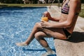 Unrecognizable teenager girl at the pool drinking healthy orange juice and having fun outdoors. Summertime and lifestyle concept Royalty Free Stock Photo