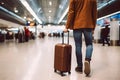 unrecognizable traveler with suitcase on wheels walking at airport hall, low angle view, neural network generated