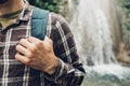 Unrecognizable Traveler Man Hands Holds Backpack Strap On Waterfall Background Hiking Journey Travel Trek Concept