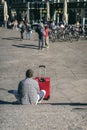 Unrecognizable traveler sitting resting on the steps near a suitcase, summer sunny day, travel and tourism concept