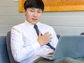 Unrecognizable unknown male businessman employee in formal business outfit sitting on cozy sofa couch with laptop holding hands on Royalty Free Stock Photo