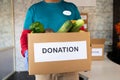 Unrecognizable volunteer holding donation box with vegetables - Concept of people volunteering to help others during coronavirus Royalty Free Stock Photo