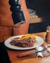 unrecognizable Waiter peppering steak in a plate Royalty Free Stock Photo
