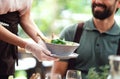 Unrecognizable waitres with gloves serving man outdoors on terrace restaurant.