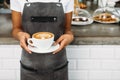 Unrecognizable waitress holding a cup of latte