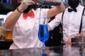 Unrecognizable waitress wearing protective face mask preparing cocktails in a pub