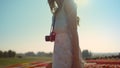 Unrecognizable woman with camera looking back at garden with spring flowers. Royalty Free Stock Photo