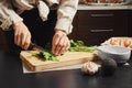 Unrecognizable woman chopping parsley in the kitchen