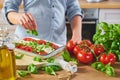 Unrecognizable woman decorating Caprese in kitchen