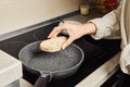 Unrecognizable woman frying bread in a frying pan