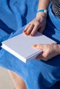 unrecognizable woman holding blank magazine for mockup design, sitting by the swimming pool Royalty Free Stock Photo