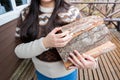 Unrecognizable woman holding bundle of firewood to the cabin in winter. She is wearing a warm wool sweater. Royalty Free Stock Photo