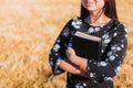 Unrecognizable christian young woman holding her bible under her arm in the field. Sola scriptura. Copy space Royalty Free Stock Photo