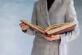 An unrecognizable woman holds a large brown book in her hands. business style, university teacher Royalty Free Stock Photo