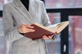 An unrecognizable woman holds a large brown book in her hands. business style, university teacher Royalty Free Stock Photo