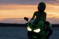 Unrecognizable woman on motorcycle at sunset