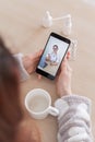 Unrecognizable woman on online consultation with a doctor on a cell phone. The girl is sick and talks to the attending Royalty Free Stock Photo