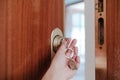 Unrecognizable woman opening door home with keys and keyring with house shape.Home and lifestyle