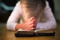 Unrecognizable woman praying, hands clasped together on her Bibl Royalty Free Stock Photo