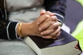 Unrecognizable woman praying, hands clasped together on her Bible Royalty Free Stock Photo