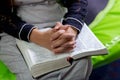 Unrecognizable woman praying, hands clasped together on her Bible Royalty Free Stock Photo