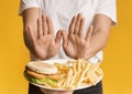 Unrecognizable Woman Rejecting Consume Plate With Junk Food, Showing Stop Gesture