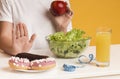 Unrecognizable woman rejecting junk food and choosing apple and salad instead Royalty Free Stock Photo