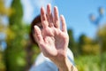 Unrecognizable woman shielding her face from camera. Concept of privacy, personal space, prohibition of photography. Female on